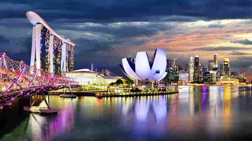 Glitzernde Skyline von Singapur rund um die Marina Bay bei Nacht.